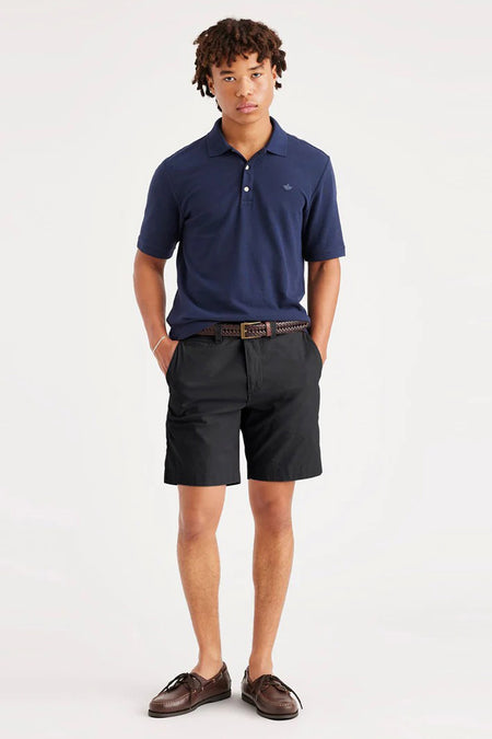 Zwarte short van DOCKERS, met een gevlochten riem en bruine schoenen.