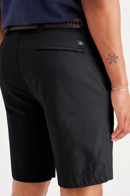 Short noir de DOCKERS, avec une ceinture tressée et une petite tatouage sur le bras.