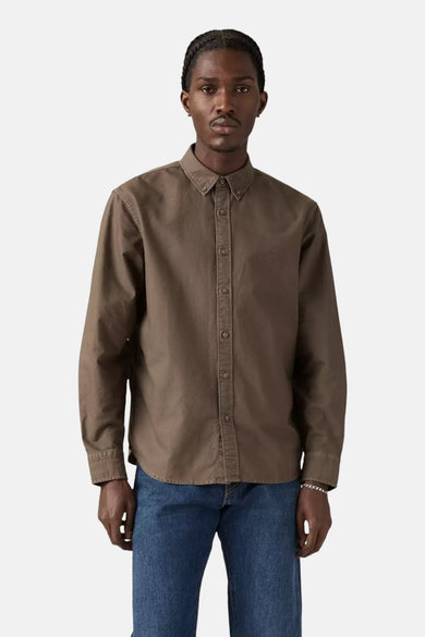 Chemise brune à longues manches de Levi's, portée avec des jeans bleus.