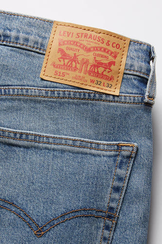 Jean droit bleu clair de Levi's, avec un étiquette sur le dos portant le nom de la marque et les informations sur le produit.