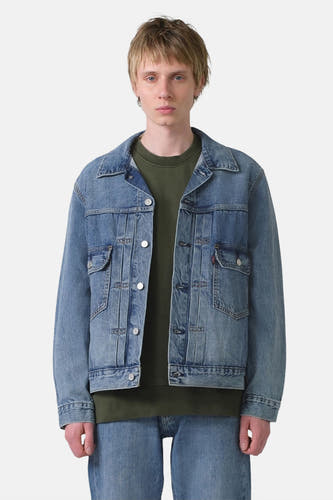 Jean de blau denim denim Levi's, avec fermeture à boutons et poches, porté avec une chemise verte et un jean.