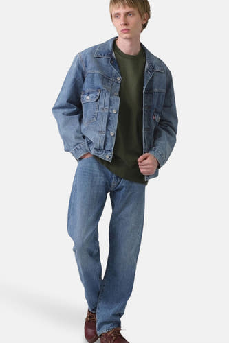 Jean de blauw denim de Levi's, porté avec un pull vert et des jeans bleus.