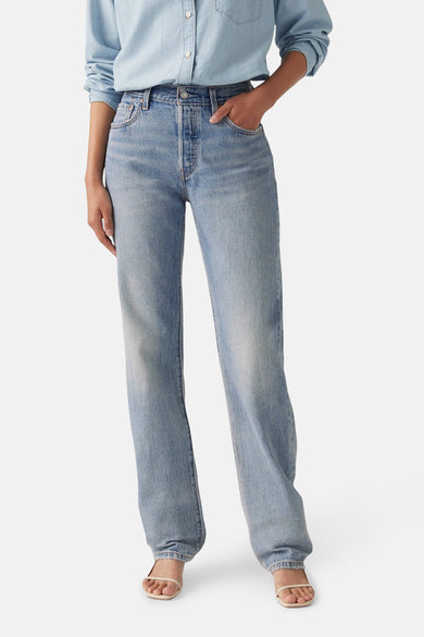 Jean droit bleu clair en denim de Levi's, avec une taille haute et un modèle droit, associé à un chemisier bleu clair.