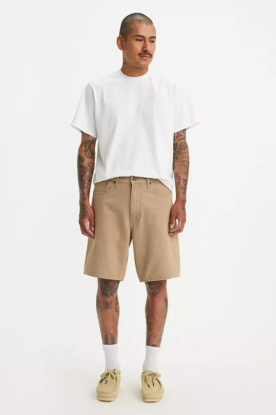 Short beige de Levi's, porté avec un T-shirt blanc, des chaussettes blanches et des chaussures beige.