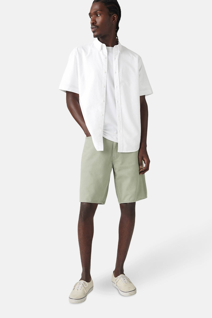 Short vert de Levi's®, combiné avec un t-shirt blanc et une chemise blanche, présenté en position debout.