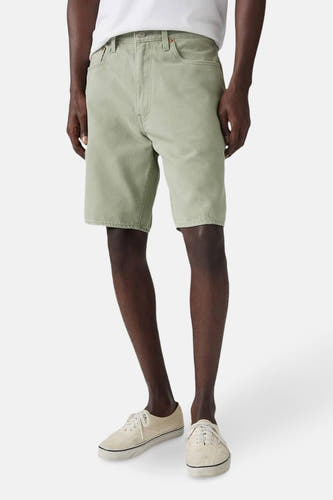 Short vert de Levi's, gedragen met crèmekleurige schoenen en een wit T-shirt tegen een witte achtergrond.