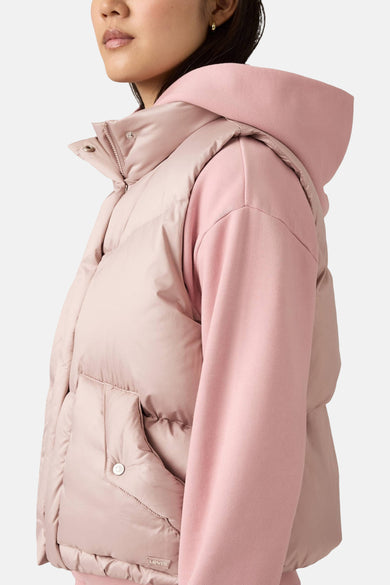 Gilet bodywarmer rose de Levi's avec des boutons-pression et une poche sur le côté, porté sur un hoodie rose.