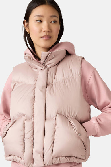 Gilet bodywarmer rose de Levi's, porté sur un hoodie rose, avec des poches et une fermeture éclair.