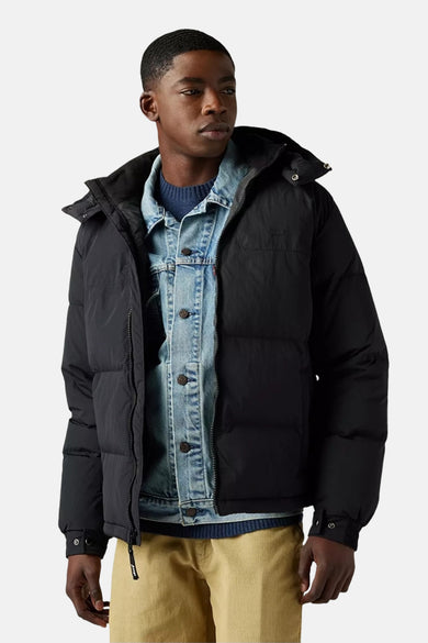 Manteau court noir de Levi's, avec capuche, porté sur un chemisier denim et une chemise bleue.