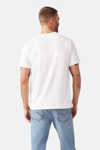T-shirt blanc à manches courtes de Levi's, vu de derrière, associé à des jeans et des tatouages sur le bras.