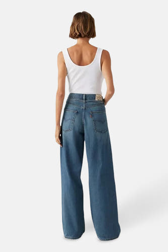 Jean droit en denim bleu de Levi's, vu de l'arrière combiné avec avec un tank top blanc.