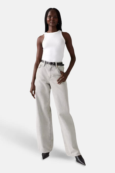 Jean droit en denim gris clair de Levi's®, vu de derrière, associé à un chemisier blanc.