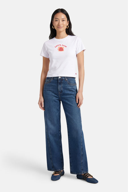 Wit T-shirt van Levi's® met een rode "Let's Jam"-print en gecombineerd met jeans en ballerina's.