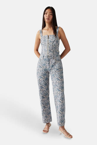 Jean droit multicolore de Levi's®, avec un motif floral et associé à des sandales.