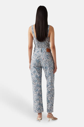 Jean Levi's multicolore avec imprimé de fleurs, associé à un haut coordonné et des sandales beige.