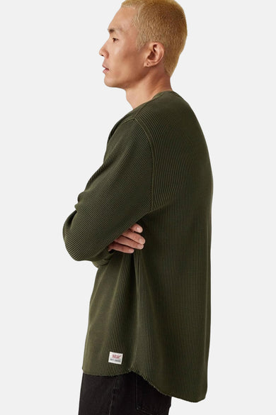 T-shirt vert de manches longues de Levi's, avec une structure à carreaux et un étiquette sur l'encolure.
