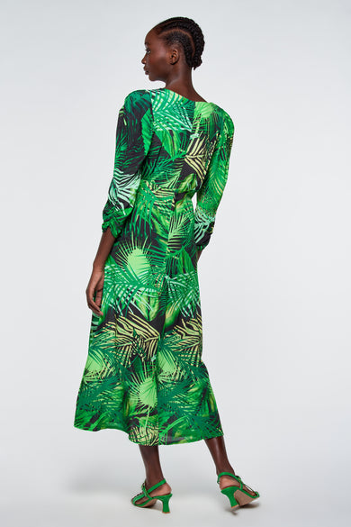Robe verte à motif de feuilles tropicales d'Astrid Black Label, manches longues, vue de côté, colorée en différentes nuances de vert sur fond sombre
