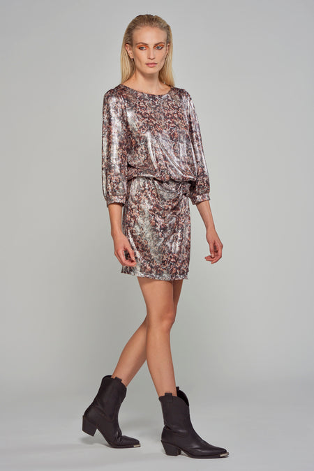 Robe d'argent à longues manches d'Astrid Black Label, avec un imprimé animal et une découpe basse dans le dos, associée à des bottes de cow-boy noires.