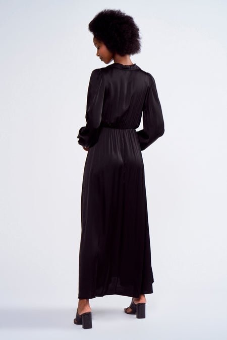 Robe noire à longues manches d'Astrid Black Label, vue de derrière, avec des plis élégants et des boutons.