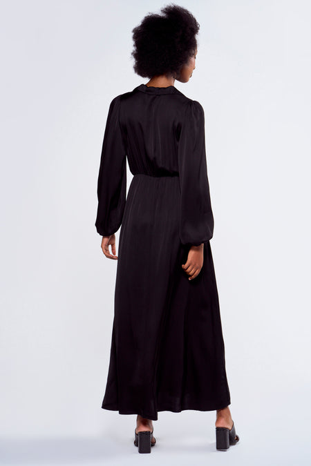 Robe noire à longues manches d'Astrid Black Label, vue de derrière, avec des manches volumineuses et une longue robe.