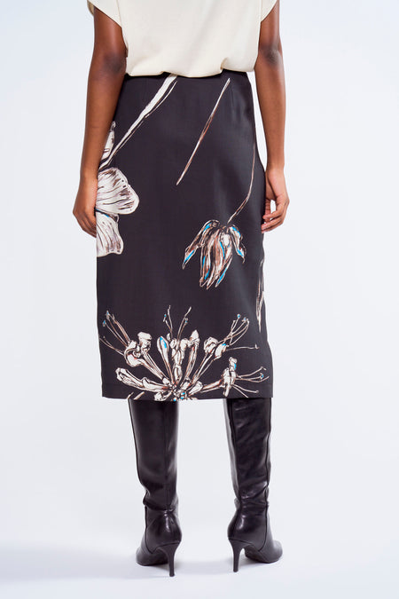 Robe multicolore d'Astrid Black Label avec un imprimé de fleurs, portée avec des bottes en cuir noires.
