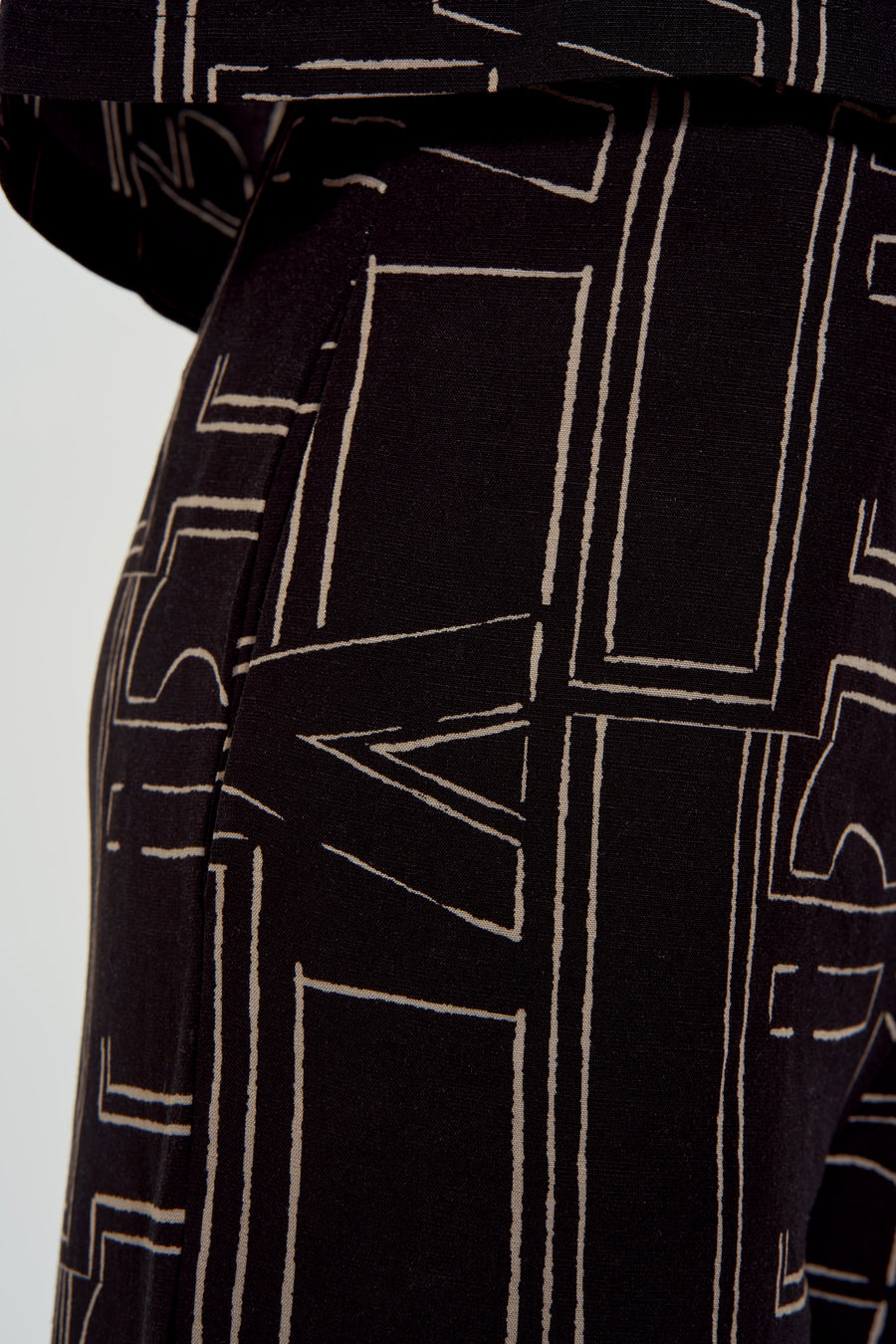 Zwart-beige broek met geometrisch patroon.