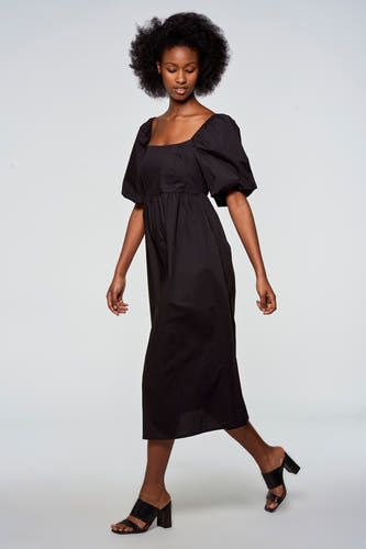 Robe noire à manches courtes d'Astrid Black Label, avec des manches bouffantes et un détail smocké sur le dos.