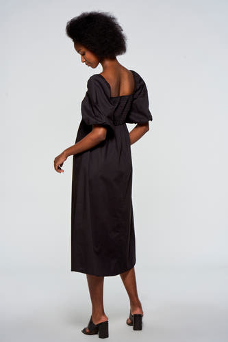 Zwarte jurk met korte mouwen van Astrid Black Label, met pofmouwen en een smock detail op de rug.
