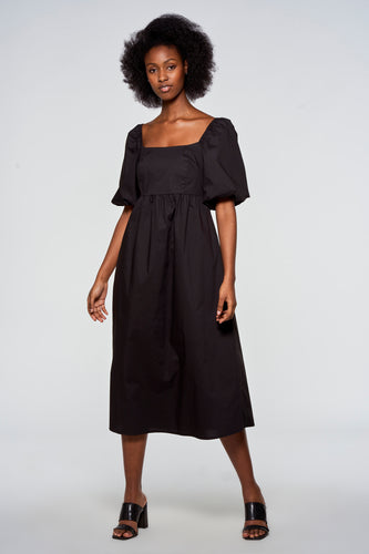 Zwarte jurk met pofmouwen en vierkante halslijn, gedragen door een model met afro haar.