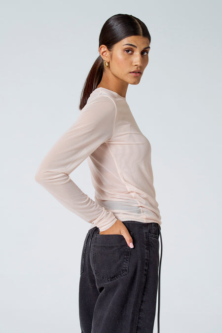 T-shirt à manches longues écru d'Astrid Black Label, tissu en mesh transparent, coupe latérale, détail noué à l'avant
