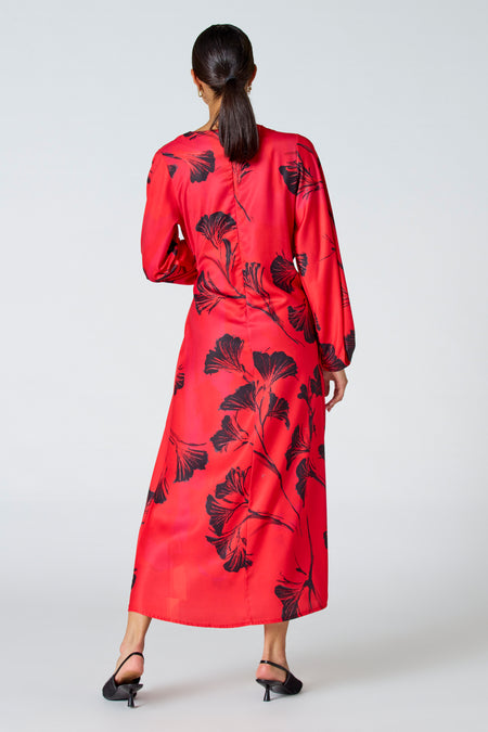 Robe rouge à longues manches d'Astrid Black Label, avec une impression de feuille noire et un subtil éclat.