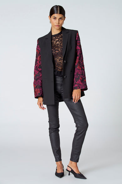 Blouse noire à manches longues d'Astrid Black Label, avec des détails noirs et une coupe cintrée.