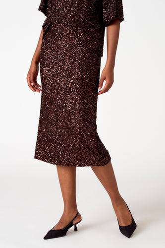 Bruine pailletten jurk met zwarte hakken.
