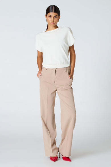 Pantalon beige d'Astrid Black Label, avec ce taille élastique et une poche arrière, détail.