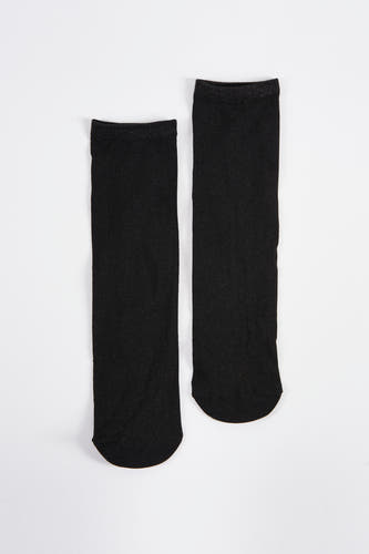 Chaussettes noires d'Astrid Black Label, avec des paillettes sur le bord, posées sur un fond blanc.