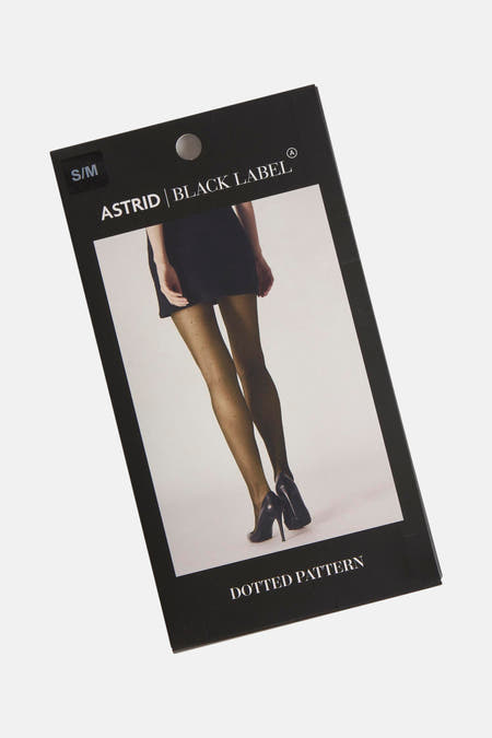 Pantys verts de Astrid Black Label, avec un motif à points, portés avec une robe noire et des talons noirs.