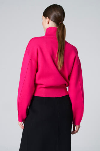 Blouse rose à col montant d'Astrid Black Label, vue de derrière, associée à une jupe noire.
