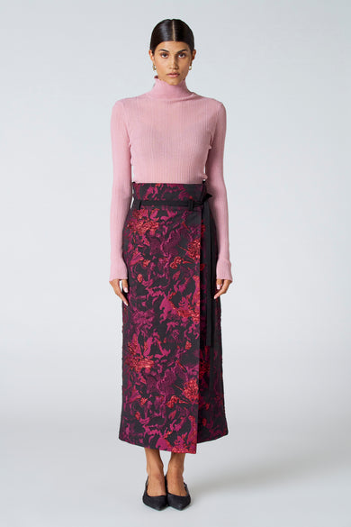 Roze ribbeltrui met rolkraag van Astrid Black Label, strak model, gedragen met een bloemenprint rok en zwarte schoenen, front view