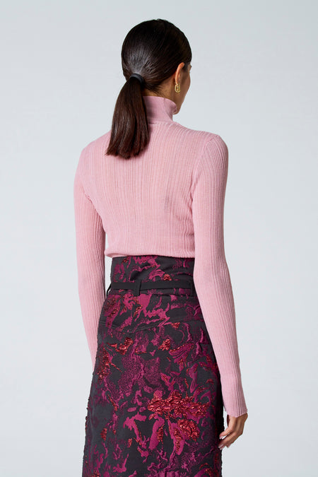 Roze ribbeltrui met rolkraag van Astrid Black Label, strak model, achterzijde, gedragen met bloemenrok