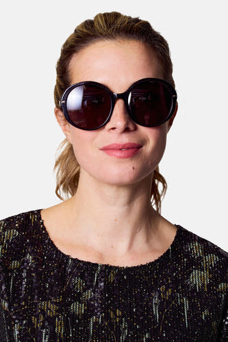 Lunettes de soleil noires d'Astrid Black Label, avec un cadre brillant et une réflexion visible.