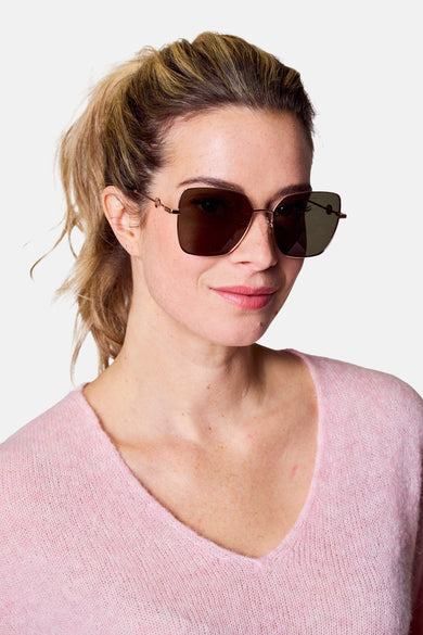Lunettes de soleil roses d'Astrid Black Label, portées avec un pull rose.