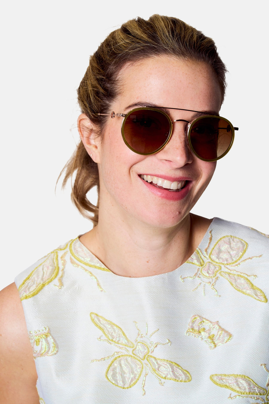 Lunettes de soleil roses d'Astrid Black Label, avec des verres marrons et une jupe bleu clair à imprimé insectes.