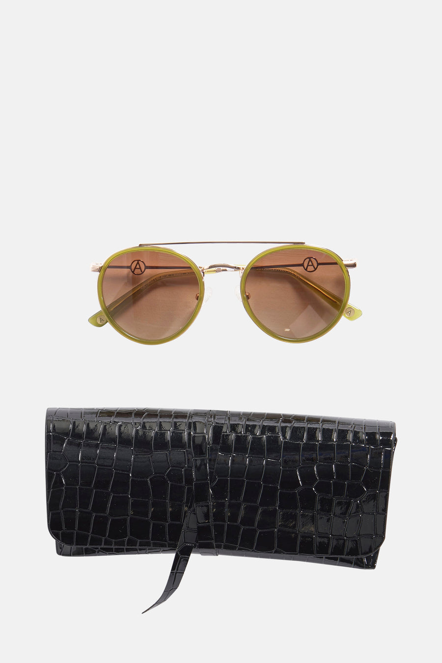 Lunettes de soleil roses d'Astrid Black Label avec un cadre doré et une boîte noire à imprimé crocodile.