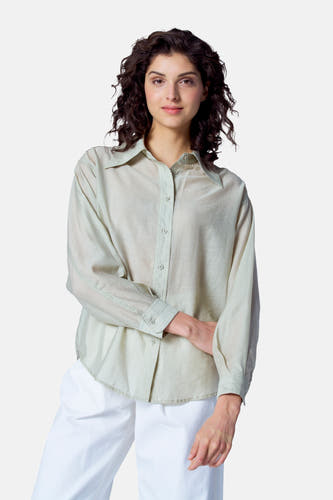 Blouse verte avec manches longues d'Astrid Black Label, portée avec un short blanc.