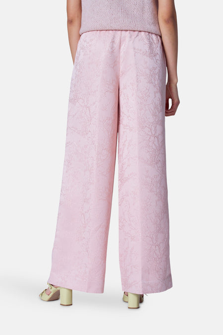 Pantalon rose d'Astrid Black Label avec un motif floral jacquard et des jambes larges, vu de derrière.