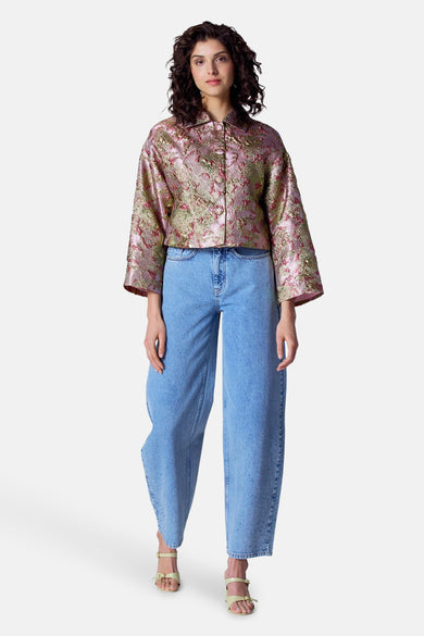 Manteau multicolore d'Astrid Black Label, avec un motif floral et porté avec des jeans larges et des sandales.