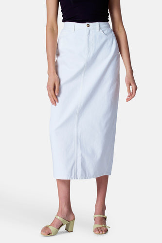 Vrouw met witte denim rok en lichtgele sandalen.
