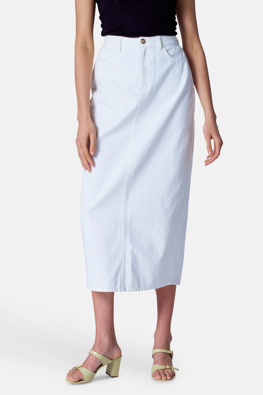 Vrouw met witte denim rok en lichtgele sandalen.
