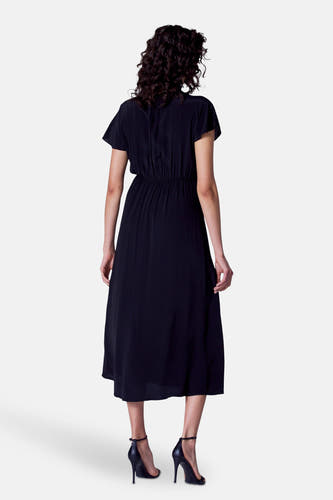 Zwarte kleedje met korte mouwen van Astrid Black Label, gezien van achteren, met elastische taille en zwarte hakken.
