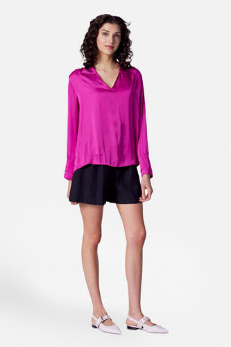 Short noir d'Astrid Black Label, porté avec une chemise rose à manches longues et des chaussures légères.